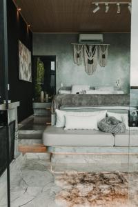 a living room with a couch and a bed at Chalé Boutique - Spa - Sauna seca , Jacuzzi , Rede suspensa in Campos do Jordão +73 photos