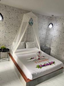 a bed with a white canopy with flowers on it at Phumaihom Resort in Hat Yai +79 photos