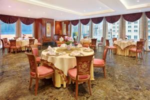 a dining room with tables and chairs and windows at The Reverie Saigon - The Leading Hotels of the World in Ho Chi Minh City