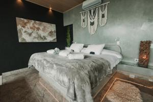 a bedroom with a bed with towels on it at Chalé Boutique - Spa - Sauna seca , Jacuzzi , Rede suspensa in Campos do Jordão