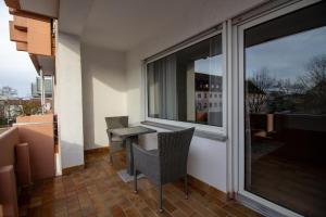 a balcony with a table and chairs and a window at Glanzvoll, moderne Wohnung in Aschaffenburg