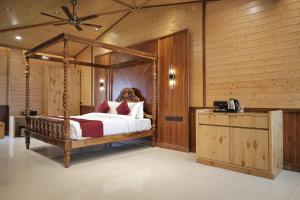 a bedroom with a canopy bed and a wooden wall at Namaste Corbett Resort and Spa in Jāmb