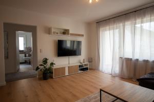 a living room with a flat screen tv on a wall at Glanzvoll, moderne Wohnung in Aschaffenburg