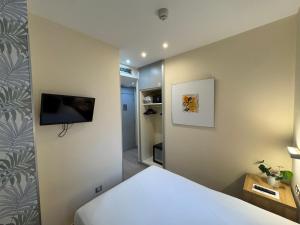 a bedroom with a bed and a tv on the wall at Welcome Gros Hotel in San Sebastián