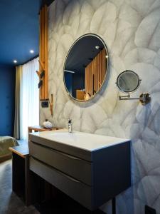 a bathroom with a sink and a mirror on a wall at Hotel Boka in Bovec +99 photos