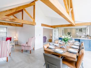 a dining room and living room with a wooden table and chairs at 5 Bed in Market Rasen oc-78678 in Tealby