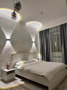 a bedroom with a large white bed and a window at Argymak Hotel Karakol in Karakol