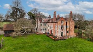 an old brick house with a green yard at Huckleberry Farm House in Basildon