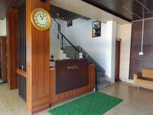 a room with a clock and a stage with a staircase at Infinity inn in Guna