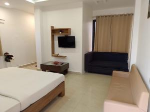 a hotel room with a bed and a couch at Infinity inn in Guna