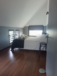 a bedroom with a large bed and a wooden floor at Villa Naiya in Saint-Paul