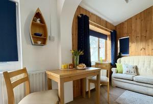 a living room with a table and a couch at Meads Cabin in Charmouth