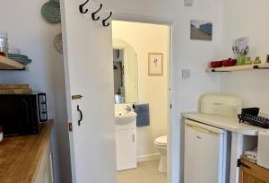 a bathroom with a toilet and a sink at Meads Cabin in Charmouth +22 photos