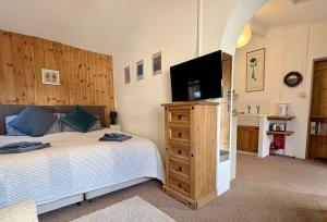 a bedroom with a bed and a flat screen tv at Meads Cabin in Charmouth