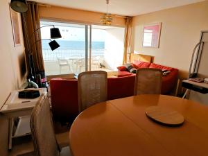 a living room with a table and a couch at Le Nid du Remblai in Les Sables-d'Olonne