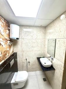 a bathroom with a toilet and a sink at GRACE Inn in Dehradun