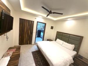 a bedroom with a bed and a ceiling fan at GRACE Inn in Dehradun