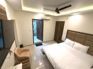 a bedroom with a bed and a chair in it at GRACE Inn in Dehradun
