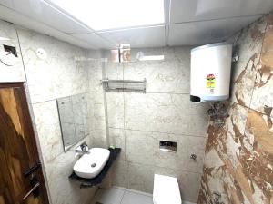 a bathroom with a sink and a toilet and a mirror at GRACE Inn in Dehradun +4 photos