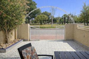 a patio with a gate and a table and chairs at Casa Moolio - Private Holiday Home with Pool Access, Walk to Beach & Restaurants in Los Alcázares