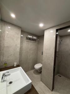 a bathroom with a sink and a toilet at RESIDENCY HOTEl in Jāmb +13 photos