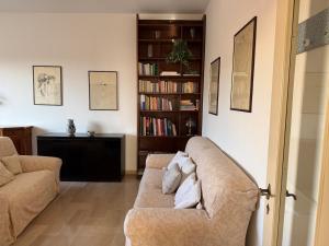 a living room with a couch and a book shelf at L' Atelier sui Tetti in Faenza