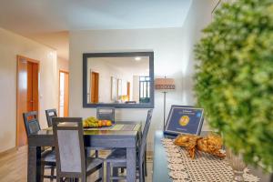 a dining room with a table and a mirror at Refugio do Sol - Madeira Inn Group in Calheta