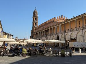a group of tables and chairs with umbrellas in front of a building at L' Atelier sui Tetti in Faenza