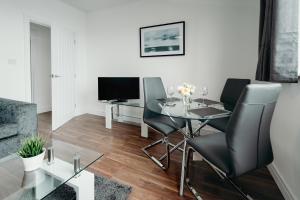 a living room with a glass table and chairs at K Suites - Station Road 13 in Hinckley