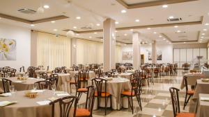 a banquet hall with white tables and chairs at Fruit Village Capo Rizzuto S Antonio in Capo Rizzuto