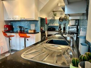a kitchen with a sink in the middle of it at 2 Bed Duplex Penthouse Apartment by Mathew Street Sleeps 6 in Liverpool