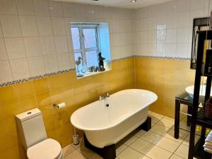 a bathroom with a tub and a toilet and a sink at 2 Bed Duplex Penthouse Apartment by Mathew Street Sleeps 6 in Liverpool +67 photos