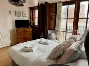 a bedroom with a large bed with pillows on it at 2 Bed Duplex Penthouse Apartment by Mathew Street Sleeps 6 in Liverpool