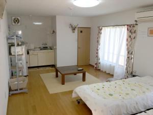 a bedroom with a bed and a table and a kitchen at Season 1 in Naoshima