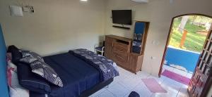a bedroom with a bed and a dresser and a television at Rancho e Pesqueiro do Cowboy in Piedade