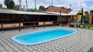 a large blue swimming pool sitting on a tiled patio at Rancho e Pesqueiro do Cowboy in Piedade +16 photos
