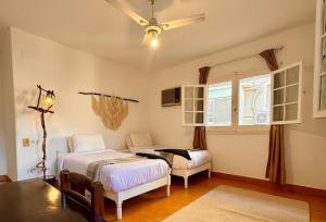 a bedroom with two beds and a ceiling fan at Villa Maadi 35 - R 205- Pool View Room in Cairo