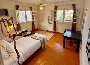a bedroom with a bed and a table and windows at Villa Maadi 35 - R 205- Pool View Room in Cairo