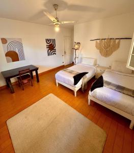 a bedroom with two beds and a table and a desk at Villa Maadi 35 - R 205- Pool View Room in Cairo
