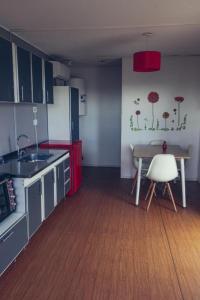 a kitchen with a table and a table and a chair at Koocoland- Xumuc in Tupungato