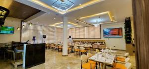 a restaurant with tables and chairs in a room at Cathelea Convention & Suites in Benin City