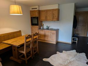 a kitchen with a wooden table and wooden cabinets at Pointe de l'Au in Val-d'Illiez