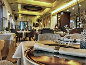 a dining room with tables and chairs and a restaurant at Familly Art Hotel Nirvana in Shumen