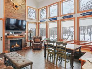 a dining room with a table and a fireplace at 692 Disciples Village Condo in Boyne Falls