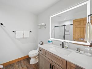 a bathroom with a sink and a toilet and a mirror at 692 Disciples Village Condo in Boyne Falls +56 photos