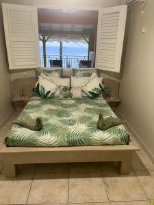 a large bed in a room with a view of the ocean at Milles Eclats in Les Anses-dʼArlets