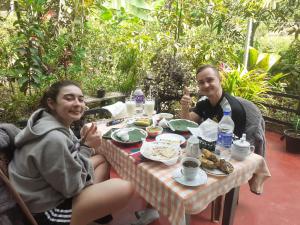 a man and woman sitting at a table eating food at Daresh home stay in Maskeliya