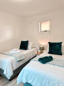 zwei Betten, die in einem Zimmer nebeneinander stehen in der Unterkunft Ebb & Flow in Hermanus