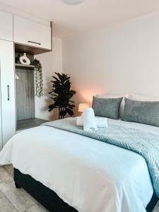 ein Schlafzimmer mit einem großen weißen Bett in einem Zimmer in der Unterkunft Ebb & Flow in Hermanus