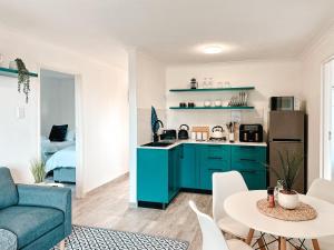 eine Küche mit blauen Schränken und ein Wohnzimmer in der Unterkunft Ebb & Flow in Hermanus